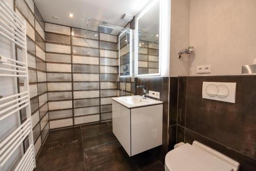 a bathroom with a toilet and a sink and a mirror at Haus "Panorama" Appartement PAN022 in Duhnen