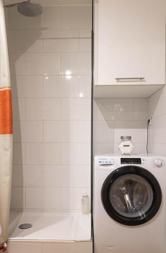 - un lave-linge et un sèche-linge dans une petite salle de bains dans l'établissement Les Écureuils - calme, parking & balcon, à Annecy