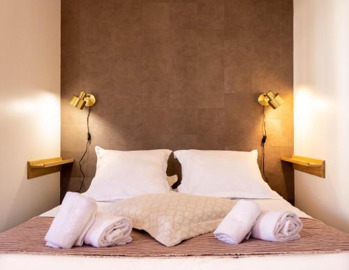 - un lit avec serviettes et deux lumières sur le lit dans l'établissement Les Écureuils - calme, parking & balcon, à Annecy