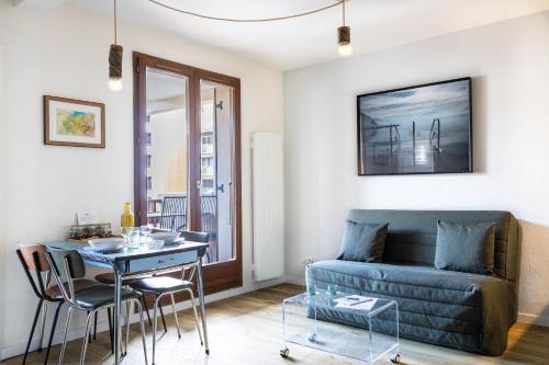 un salon avec un canapé et une table dans l'établissement Les Écureuils - calme, parking & balcon, à Annecy