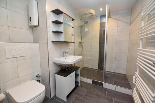 a bathroom with a toilet and a sink and a shower at Haus "Panorama" Appartement PAN024 in Duhnen