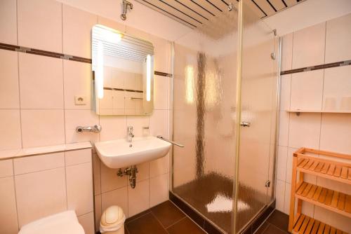 a bathroom with a shower and a sink and a toilet at Haus "Panorama" Appartement PAN027 in Duhnen