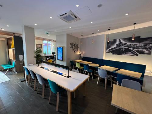 a restaurant with rows of tables and chairs at Holiday Inn Paris-Auteuil by IHG in Paris
