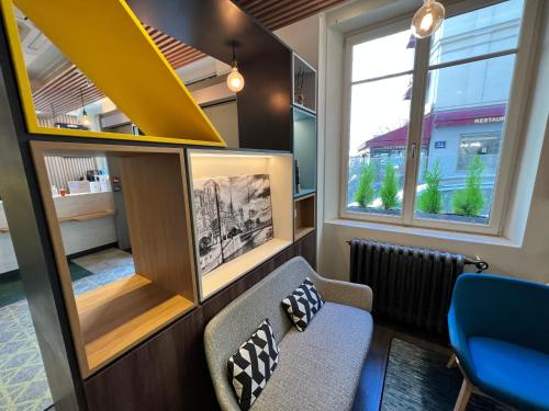 a living room with a couch and a window at Holiday Inn Paris-Auteuil by IHG in Paris