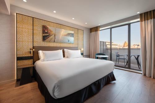 a bedroom with a large bed and a large window at Eurostars Aliados in Porto