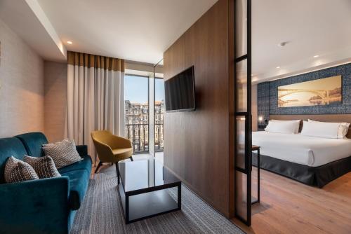 a hotel room with a bed and a couch at Eurostars Aliados in Porto