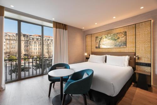 a hotel room with a bed and a table and chairs at Eurostars Aliados in Porto