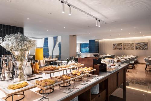 a buffet line with food on display in a restaurant at Eurostars Aliados in Porto