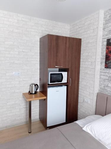 eine kleine Küche mit einer Mikrowelle auf dem Kühlschrank in der Unterkunft Chusovskaya Hotel in Zavod Chusovskoye