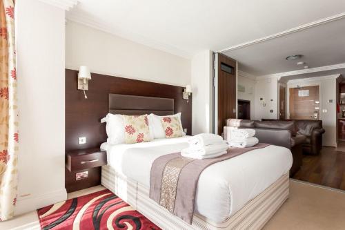 um quarto com uma grande cama branca e um grande espelho. em Swallows em Bournemouth