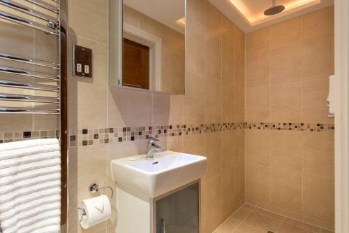 uma casa de banho com um lavatório e um espelho em Swallows em Bournemouth