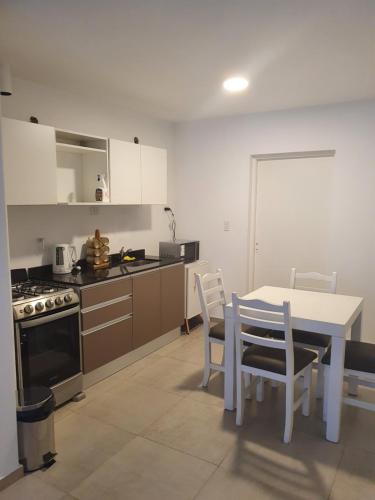 uma cozinha com uma mesa e uma mesa e cadeiras em Duplex Jardines del Rey em Neuquén