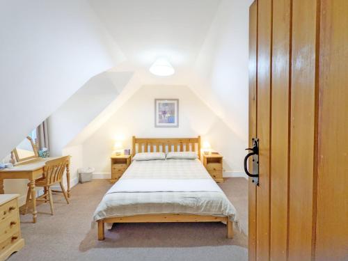 ein Schlafzimmer mit einem Bett, einem Schreibtisch und einer Treppe in der Unterkunft Vane Cottage - Lewes in Lewes