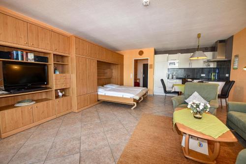 a living room with a tv and a couch and a bed at Haus "Panorama" Appartement PAN102 in Duhnen