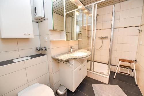 a bathroom with a toilet and a sink and a shower at Haus "Panorama" Appartement PAN102 in Duhnen