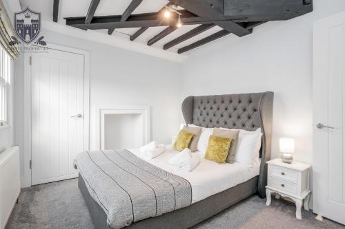 A bed or beds in a room at Castle Properties: The Sovereign 5 Bed Town House