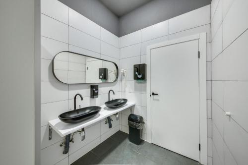 a bathroom with two sinks and a mirror at MOONOTEL Maidan in Kyiv