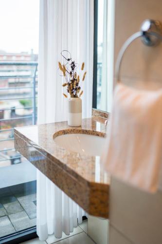 a bathroom with a sink and a large window at KONCEPT HOTEL Benedikt in Siegburg