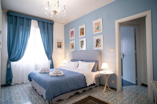 巴勒莫Scirocco House的一间蓝色卧室,配有一张床和一个吊灯