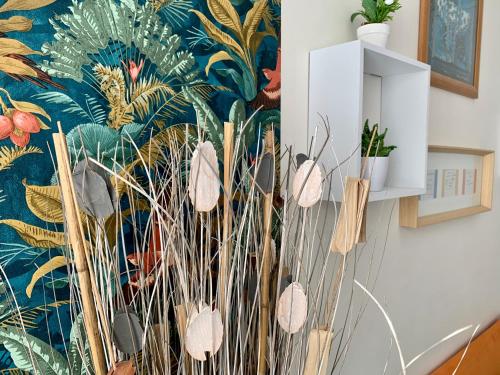 a living room with a wall with a floral wallpaper at LE COSY Canet - Studio pour 2 personnes à 30m de la plage in Canet-en-Roussillon