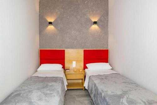 two beds in a small room with red headboards at Castristudios in Nikiti