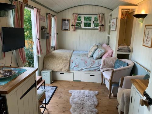 a small bedroom with a bed and a couch at Thatched Cottage in Pulborough
