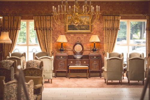 uma sala de estar com uma mesa e cadeiras e um lustre em Corick House Hotel & Spa em Clogher