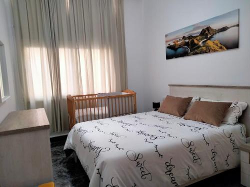 sypialnia z łóżkiem z białą kołdrą w obiekcie APARTAMENTOS La PEÑA C w mieście La Guancha