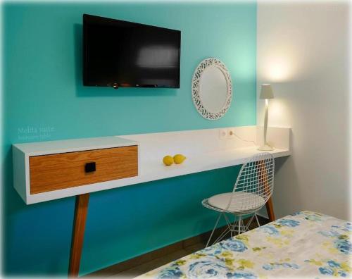 a bedroom with a tv on a blue wall at Castristudios in Nikiti