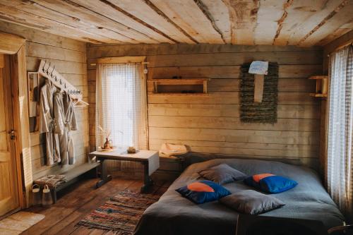 a bedroom with a bed in a wooden room at Jūrkalnes Meža SPA in Ošvalki