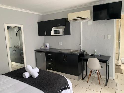 a bedroom with a bed and a desk with a microwave at 11 On Grace in East London