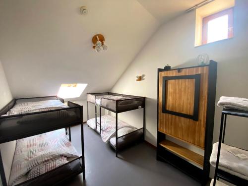 Cette chambre mansardée comprend 3 lits superposés et un miroir. dans l'établissement Auberge du Savel, à Clavans-en-Haut-Oisans