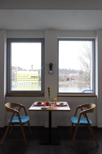 two windows in a room with a table and two chairs at Botel Racek in Prague