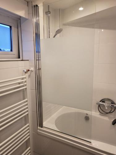 a bathroom with a tub and a glass shower door at Luxe vakantiehuisje in prachtige en rustgevende omgeving in Nieuwe-Niedorp