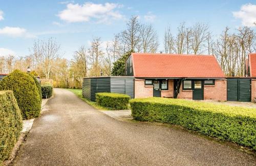 a house with a red roof and a road at Luxe vakantiehuisje in prachtige en rustgevende omgeving in Nieuwe-Niedorp