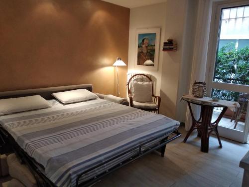 a bedroom with a bed and a chair and a window at La Casetta - Near the sea & free parking in Rapallo