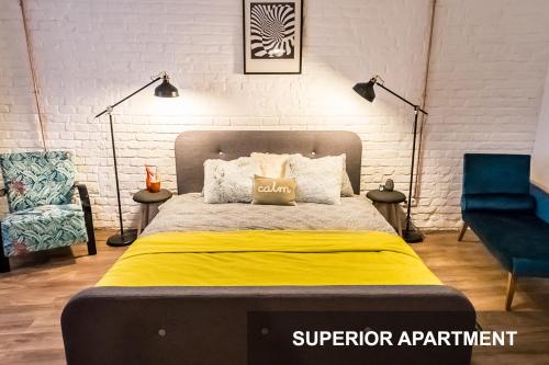 a bedroom with a bed and a chair and lights at BpR Whistle Arts Industrial Apartment in Budapest