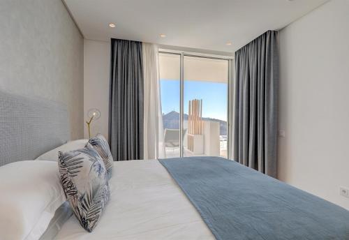 - une chambre avec un lit et une grande fenêtre dans l'établissement Luxury apt in the hills of Marbella, à Ojén