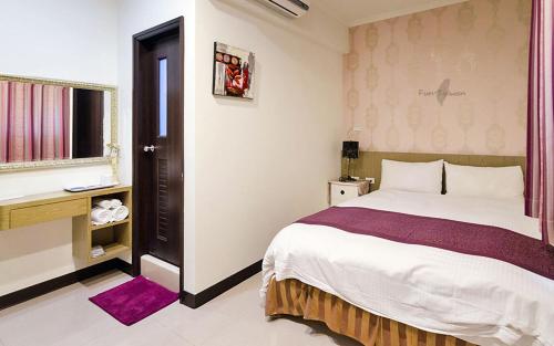 a bedroom with a large bed and a window at Tainan Yi Zhan in San-fen-tzu