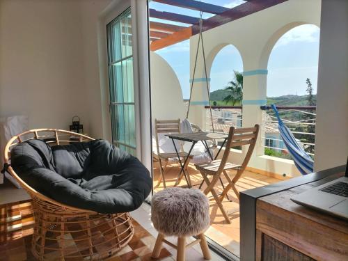 a living room with a chair and a table at Komfortables Town House in traumhafter Lage in Budens
