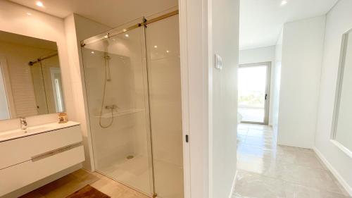 a white bathroom with a shower and a sink at Alvorada Premium by Sunny Deluxe in Albufeira