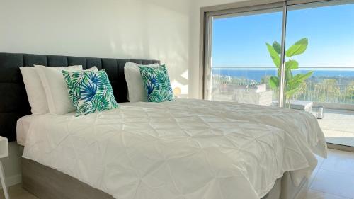 a bedroom with a large bed with a large window at Alvorada Premium by Sunny Deluxe in Albufeira