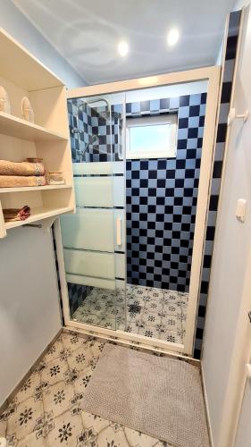 une douche avec une porte vitrée dans une salle de bain dans l'établissement Ô de Caps - à 50m de la plage, à Sangatte