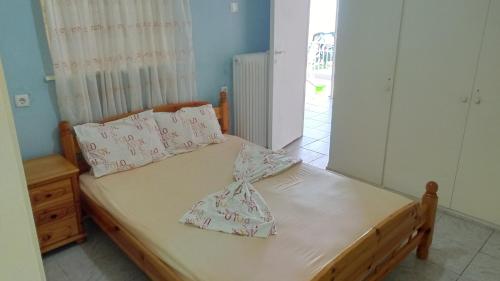 1 dormitorio con 1 cama con sábanas y almohadas blancas en RESTH, en Salamina