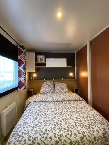 une chambre avec un grand lit dans une pièce dans l'établissement Mobil home Rainbow, camping les dunes de contis, à Saint-Julien-en-Born