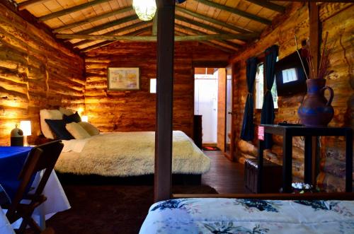 a bedroom with a bed in a log cabin at Castillo Casablanca in Guatavita