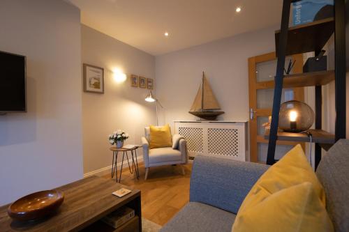 a living room with a loft bed and a chair at Silverdale Mews in Eastbourne