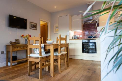 a kitchen with a table and chairs and a television at Silverdale Mews in Eastbourne