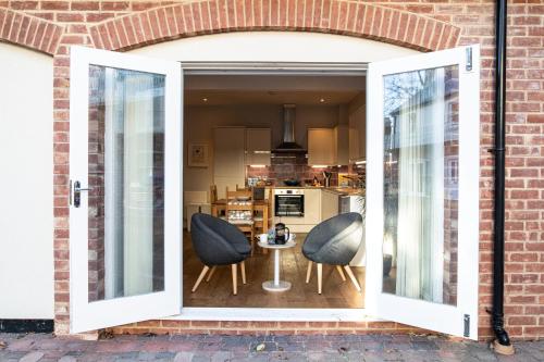 an open door to a kitchen with two chairs and a table at Silverdale Mews in Eastbourne