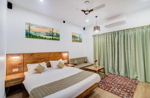 a bedroom with a bed and a green curtain at Hotel Malas in Panchgani